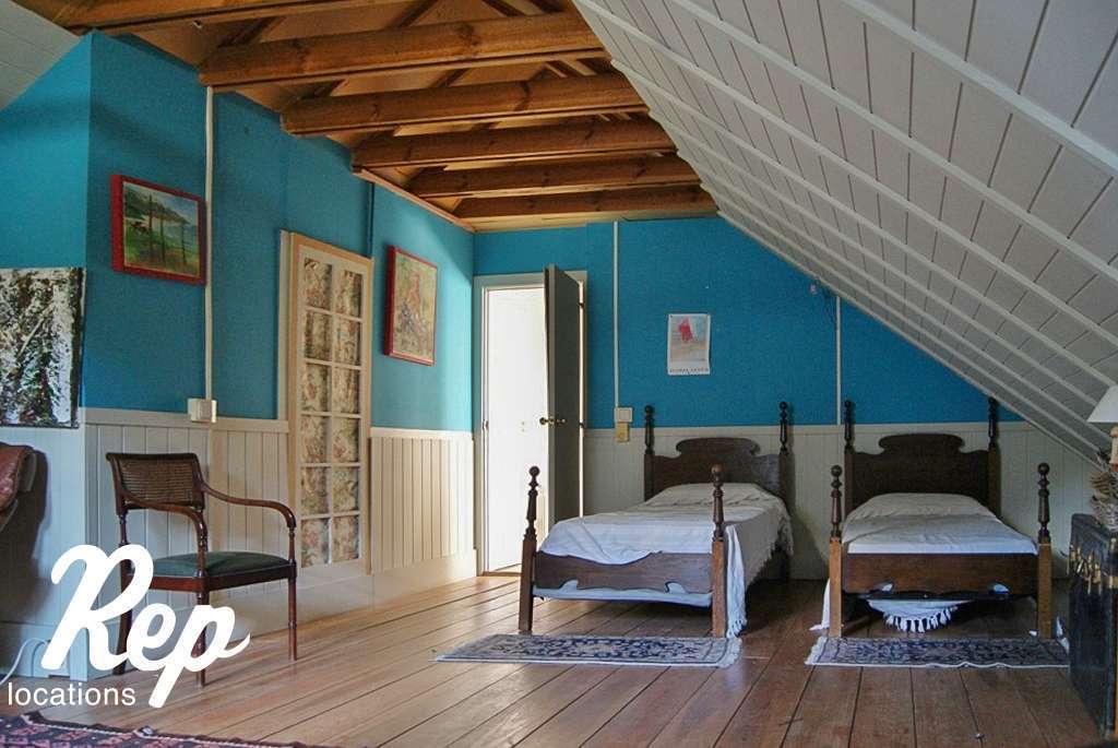 Habitación con dos camas y techo abuhardillado