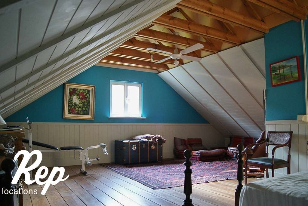 Habitación con techo abuhardillado y ventana